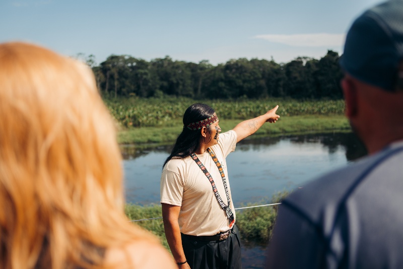 Local Achuar guide giving two people a tour