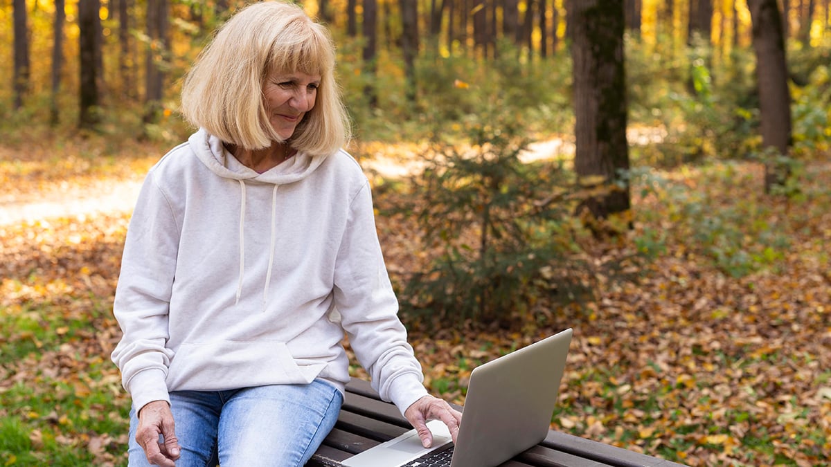 older-woman-outdoors-using-laptop-1200x675
