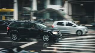 black car and silver car driving on wet road