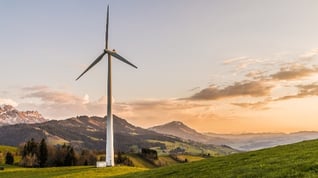 wind turbine with mountain and grass in background