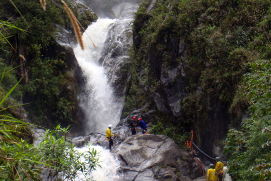 people hiking next to waterfall