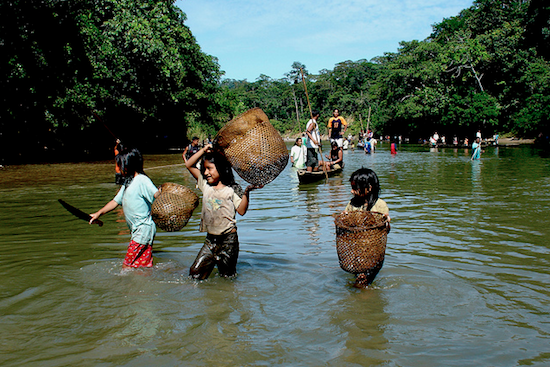 children holding baskets while wading in the Amazon river