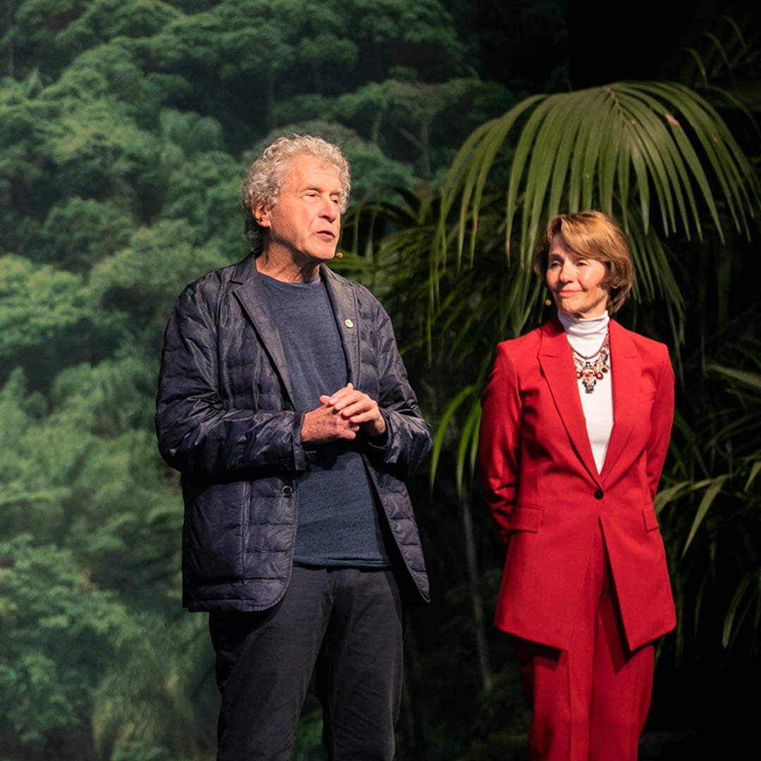 man and woman on stage speaking to an audience