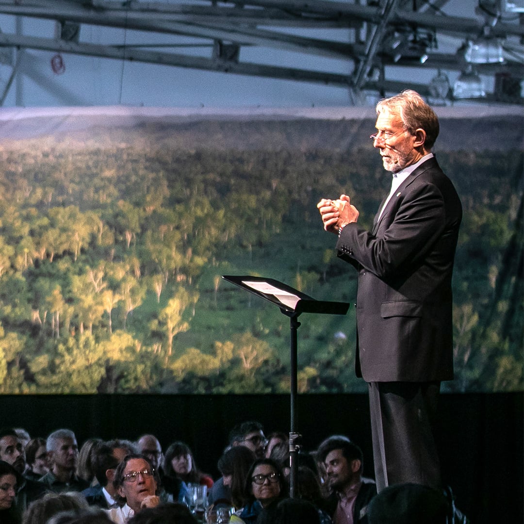 man on stage speaking to an audience