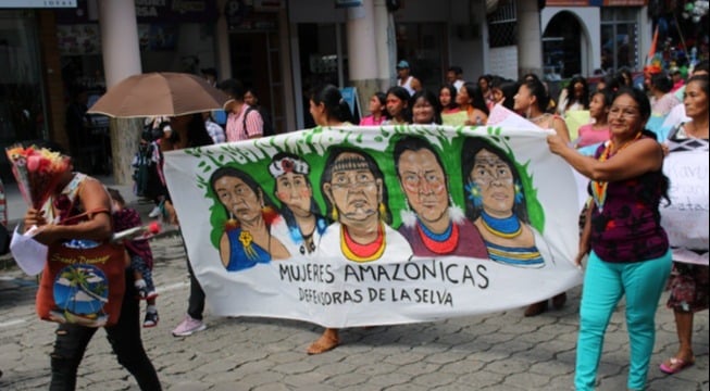 women holding mujeres amazonicas banner during demonstration in ecuador