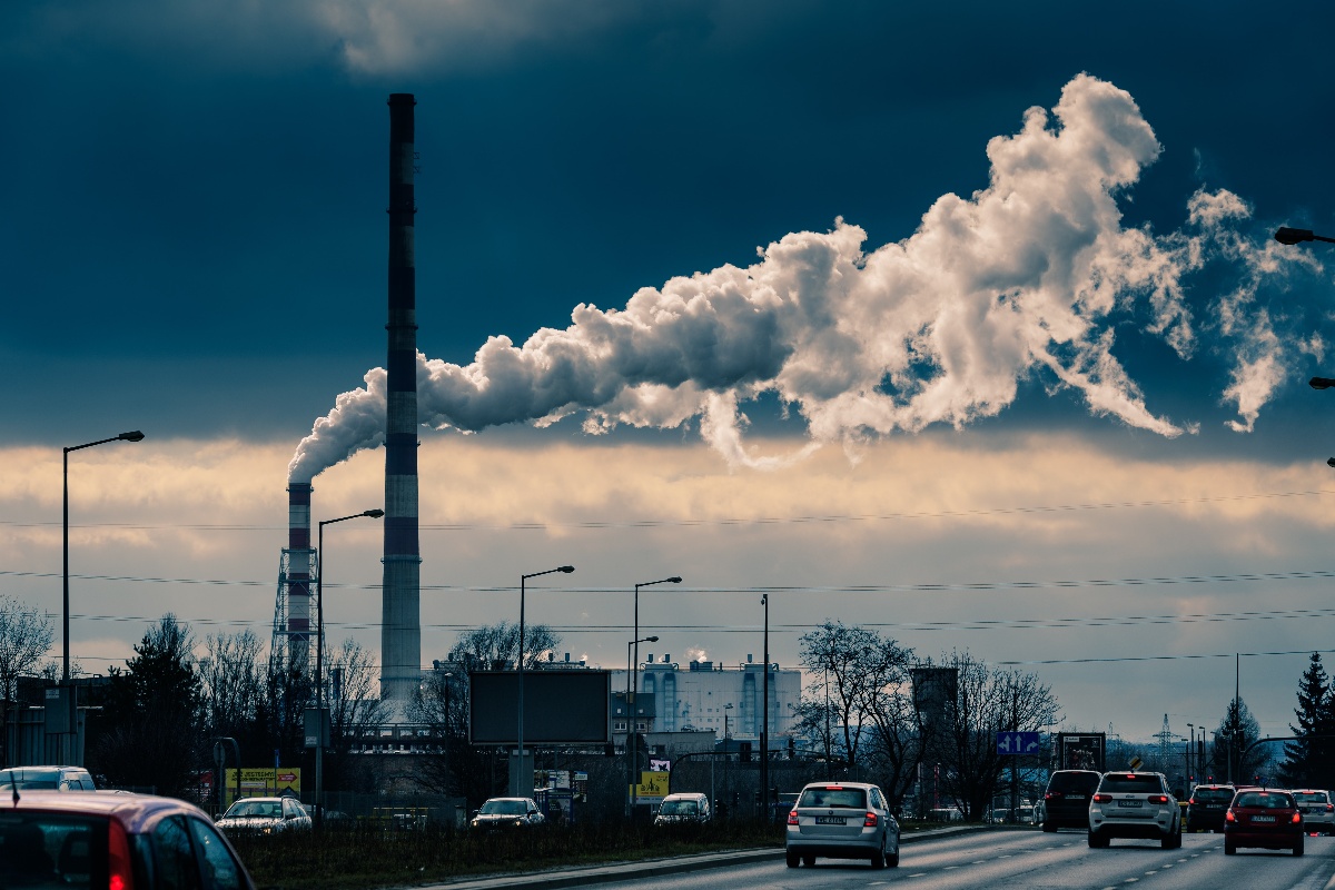 factory emissions billowing above highway