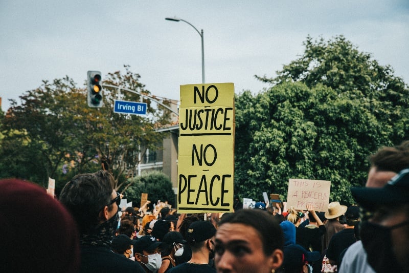 protestor with sign about justice and peace